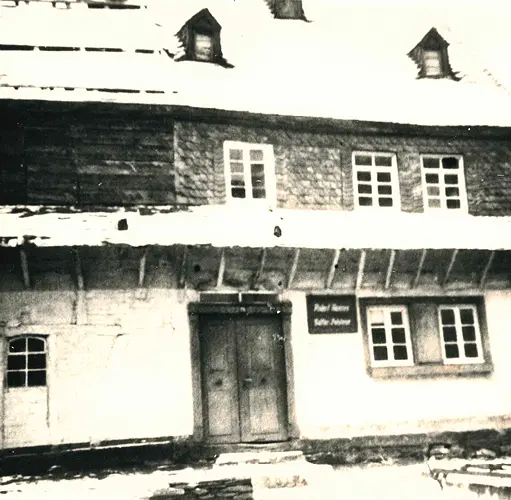 Wohnzimmer mit moderner Wohnwand in Weiß und Holzoptik, beleuchteten Regalen und großem TV – Wohnzimmereinrichtung mit Stauraum, Designmöbel in Naturtönen, Kombination aus Funktion und Ästhetik.